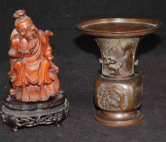 A Japanese hardwood carving of a sage and a bronze vase